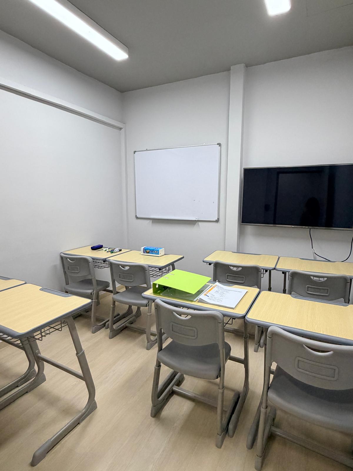 A classroom with whiteboard and TV screen